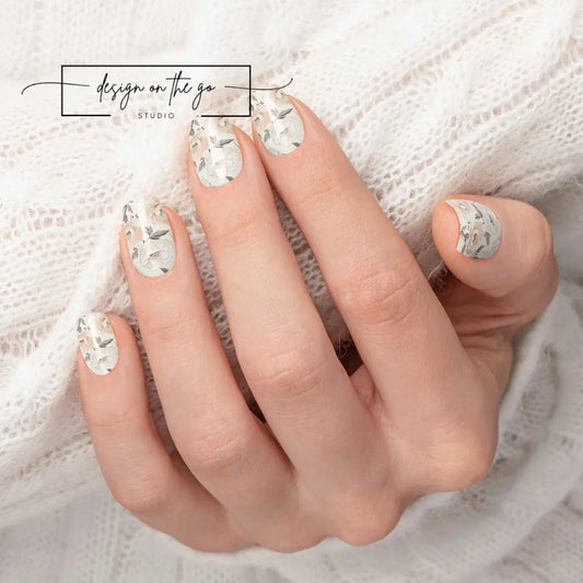 #type_manicure beautifully manicured hand showing nails with nail wraps applied on white sweater