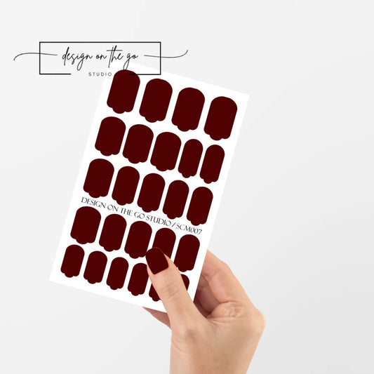 #type_manicure single hand with beautifully manicured nails with nail wraps holding full nail wraps sheet.