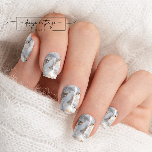 #type_manicure beautifully manicured hand showing nails with nail wraps applied on white sweater