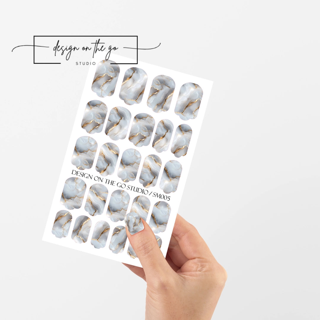 #type_manicure single hand with beautifully manicured nails with nail wraps holding full nail wraps sheet.