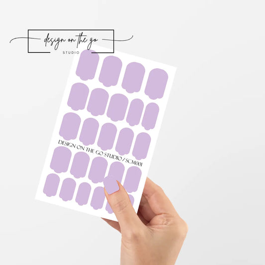 #type_manicure single hand with beautifully manicured nails with nail wraps holding full nail wraps sheet.