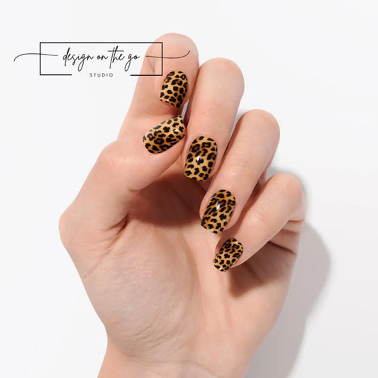 #type_manicure Hand with leopard print nail design on a light background