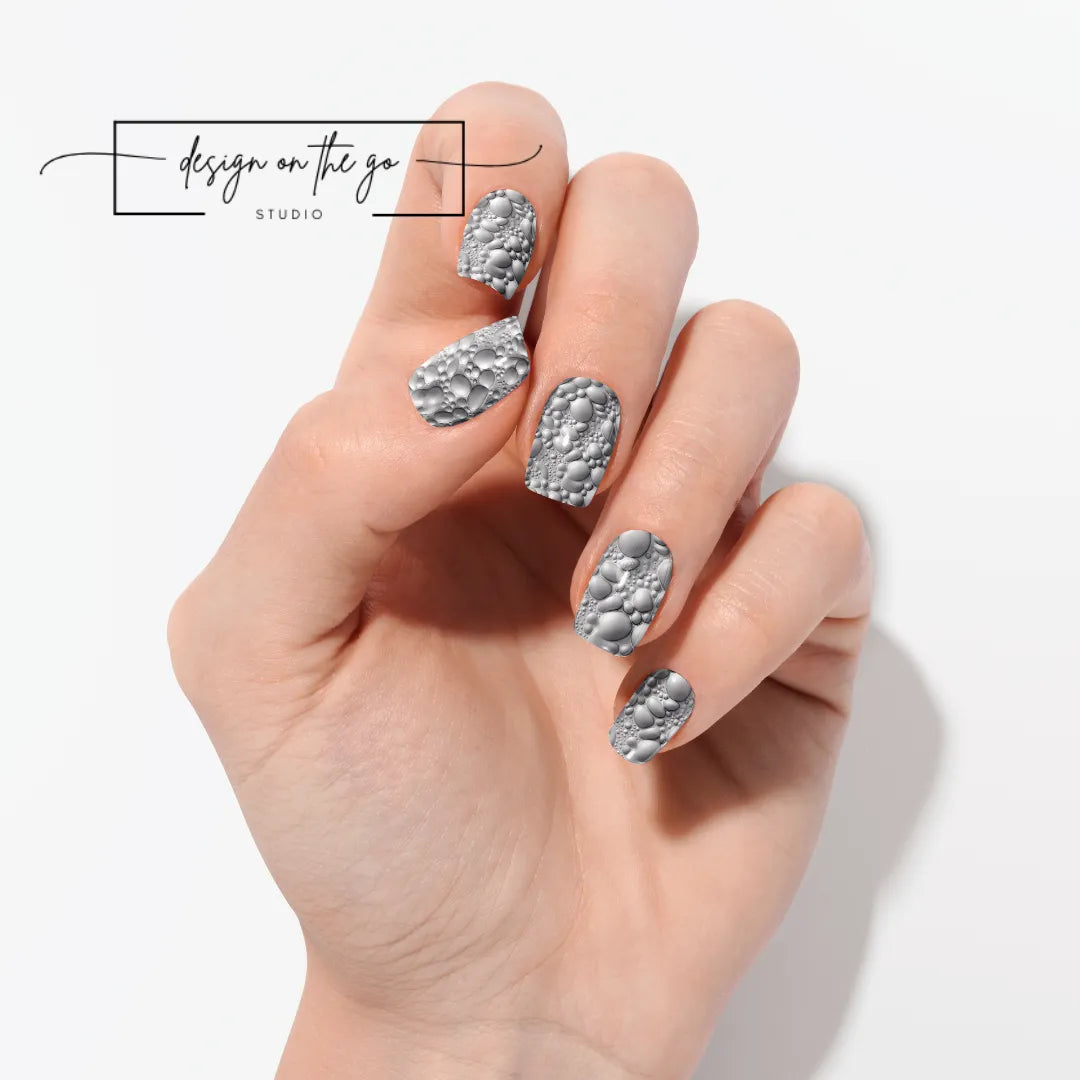 #type_manicure one hand showing beautifully manicured nail with nail wraps applied on white background