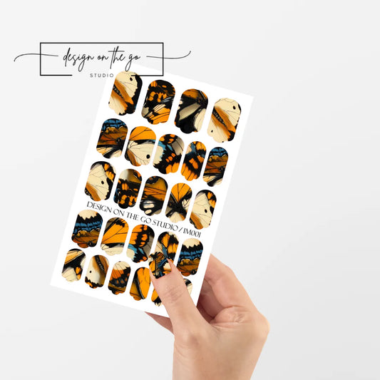 #type_manicure single hand with beautifully manicured nails with nail wraps holding full nail wraps sheet.