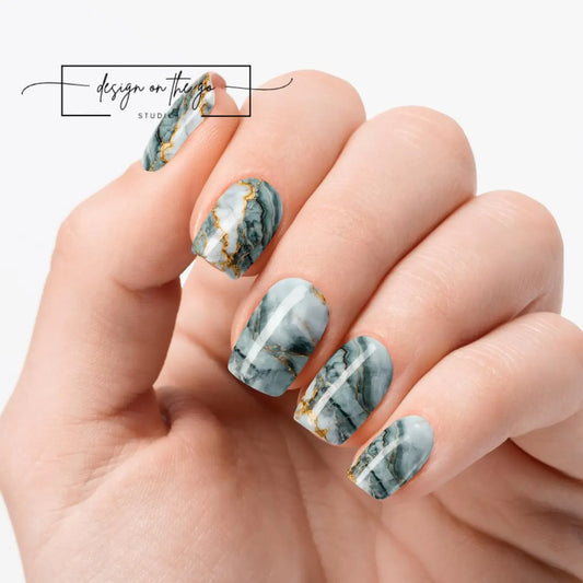 Hand with marbleized nail design on a white background