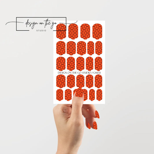 #type_manicure single hand with beautifully manicured nails with nail wraps holding full nail wraps sheet.