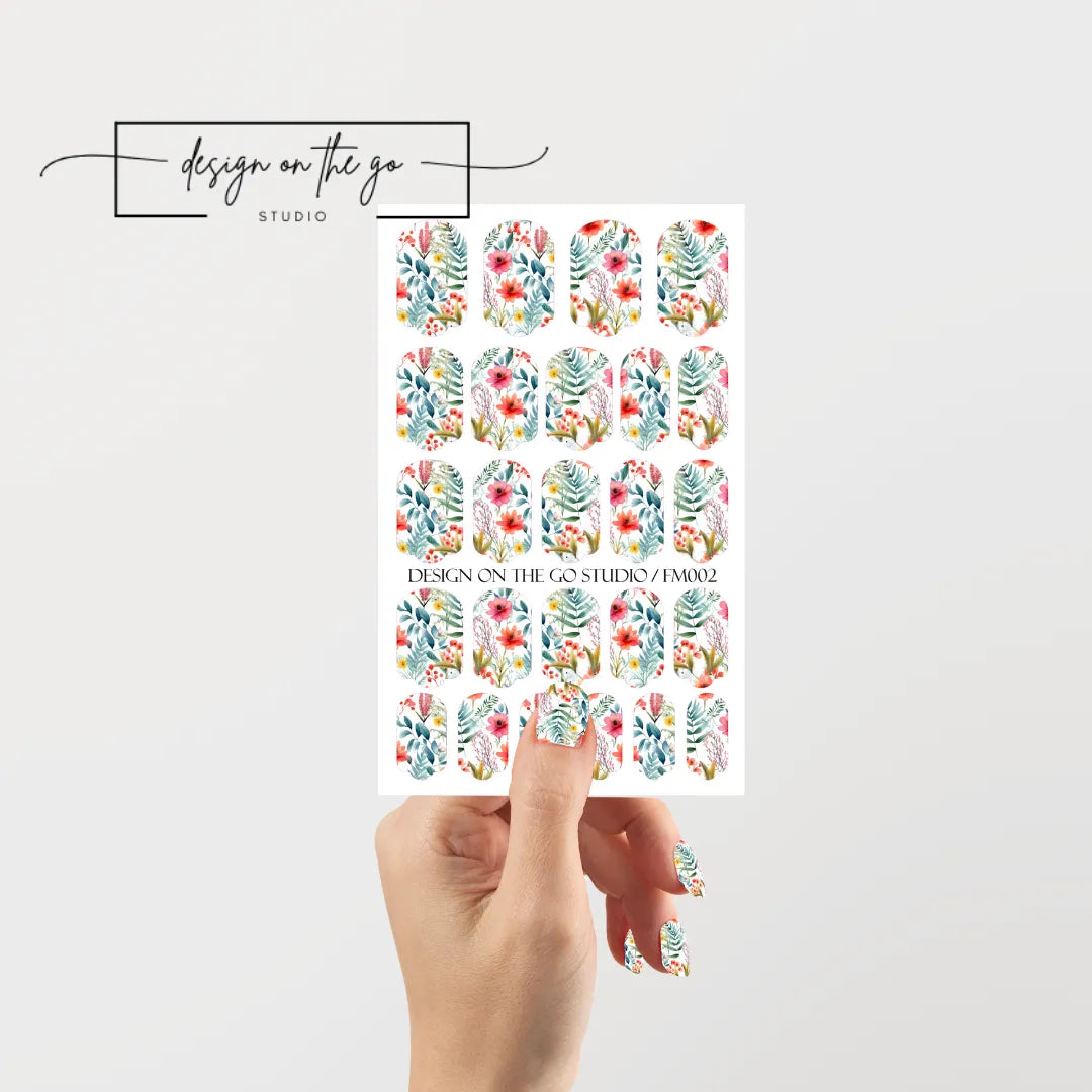 #type_manicure single hand with beautifully manicured nails with nail wraps holding full nail wraps sheet.