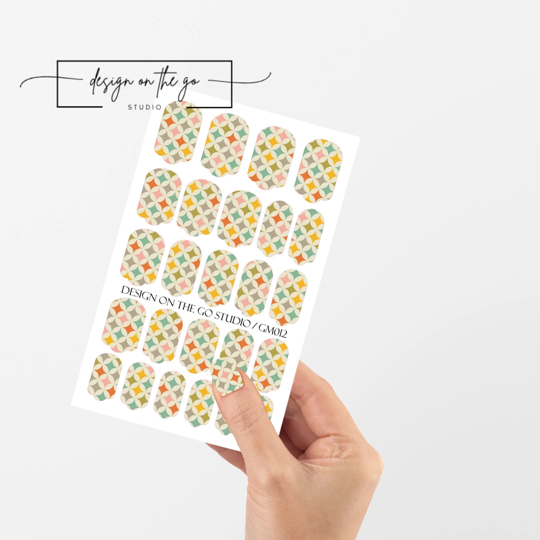 #type_manicure single hand with beautifully manicured nails with nail wraps holding full nail wraps sheet.