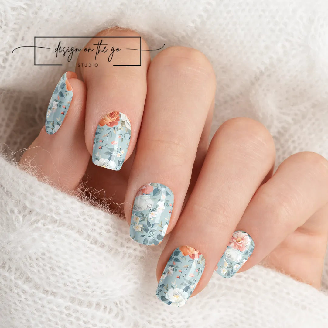 #type_manicure beautifully manicured hand showing nails with nail wraps applied on white sweater