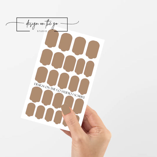 #type_manicure single hand with beautifully manicured nails with nail wraps holding full nail wraps sheet.