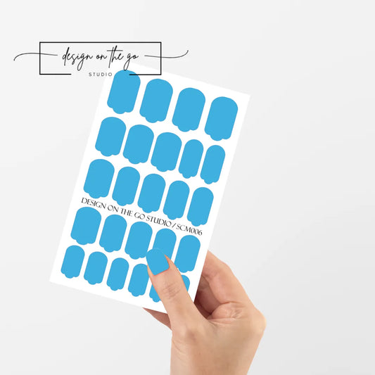 #type_manicure single hand with beautifully manicured nails with nail wraps holding full nail wraps sheet.