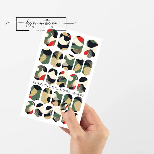 #type_manicure single hand with beautifully manicured nails with nail wraps holding full nail wraps sheet.