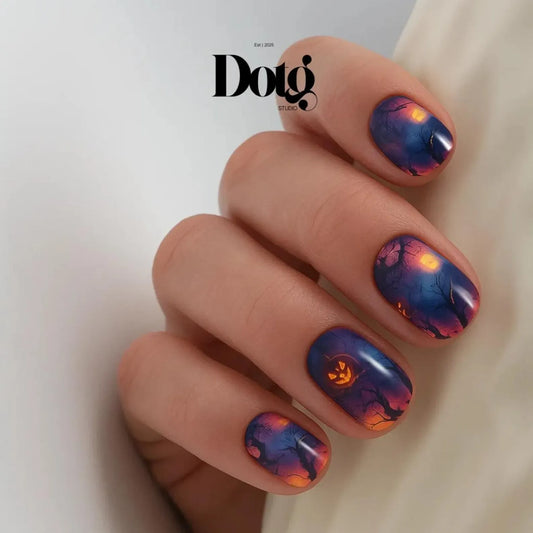 #type_manicure Hand with Halloween-themed nail art featuring a moon, tree, and pumpkin on a white background.