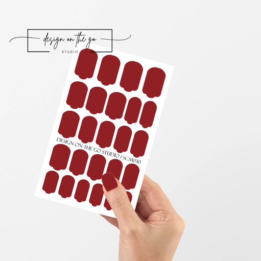 #type_manicure single hand with beautifully manicured nails with nail wraps holding full nail wraps sheet.