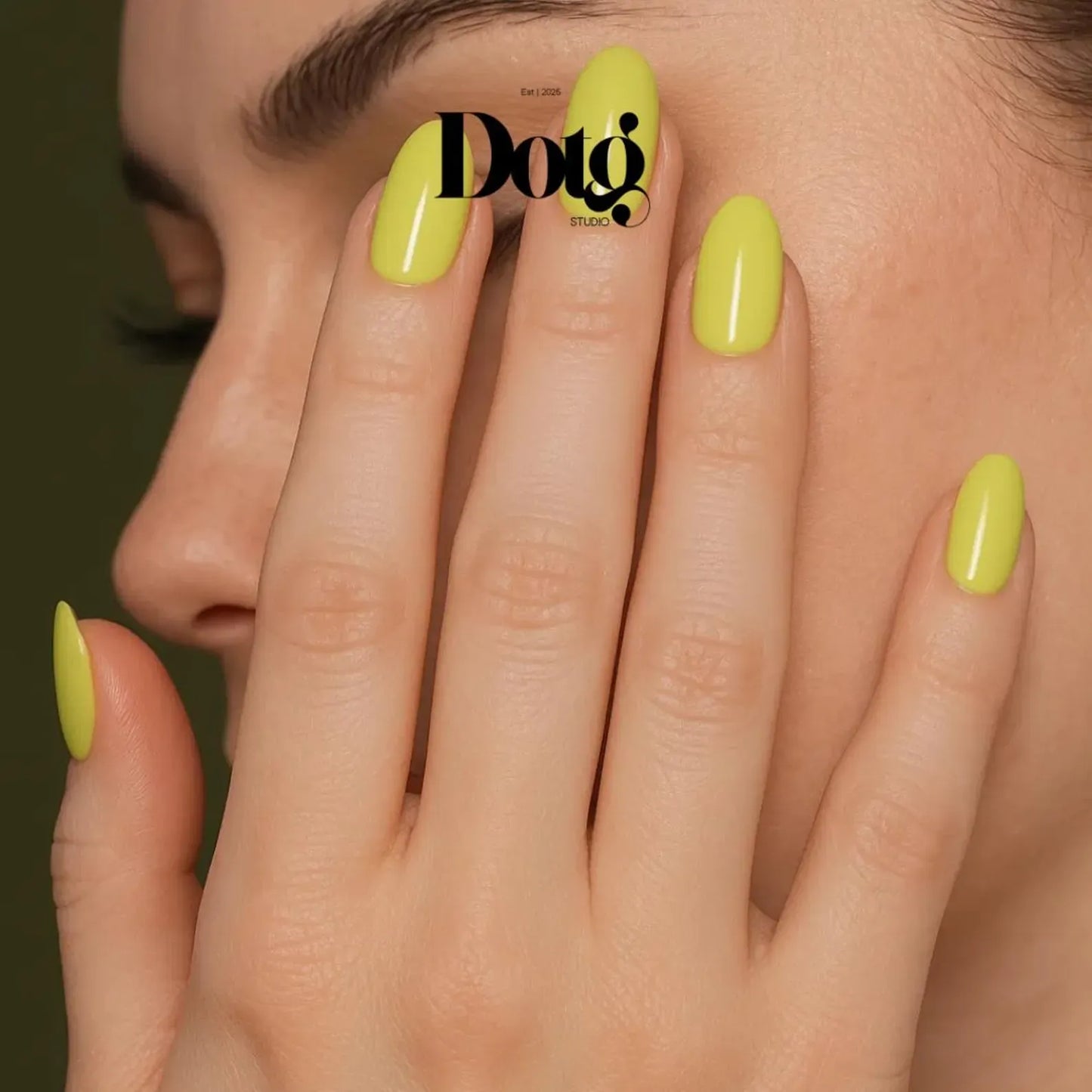 Close-up of a hand with bright green nails against a dark background, featuring the Dotg Studio brand.