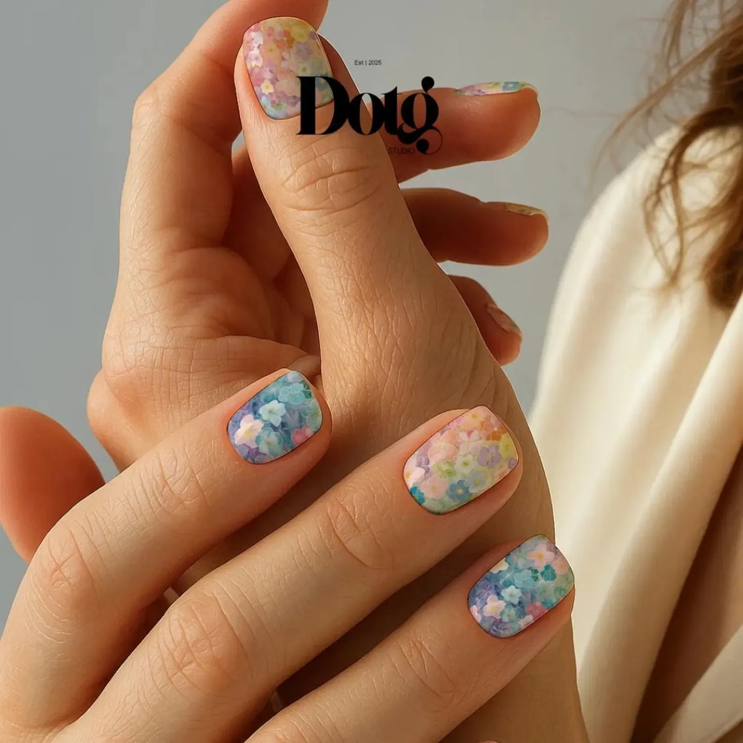 Hand with floral nail art holding a blurred background