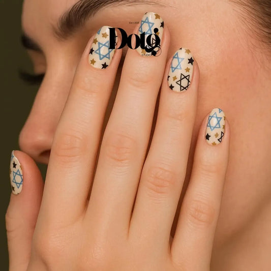 Close-up of a manicured hand with decorated nails with nail wraps featuring star designs
