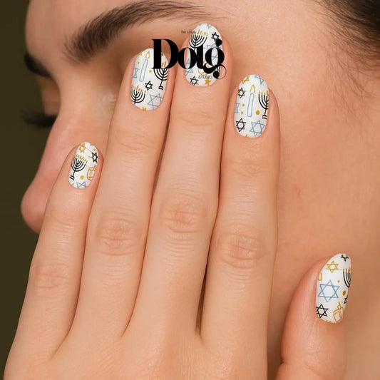 Close-up of a hand with nail art featuring menora, dreidel and geometric patterns