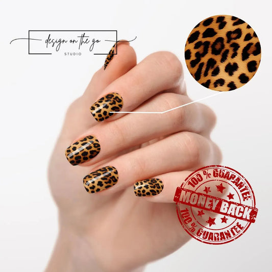 Hand with leopard print nail design on a white background, featuring 'Design on the Go Studio' logo.