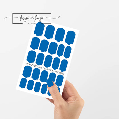 #type_manicure single hand with beautifully manicured nails with nail wraps holding full nail wraps sheet.