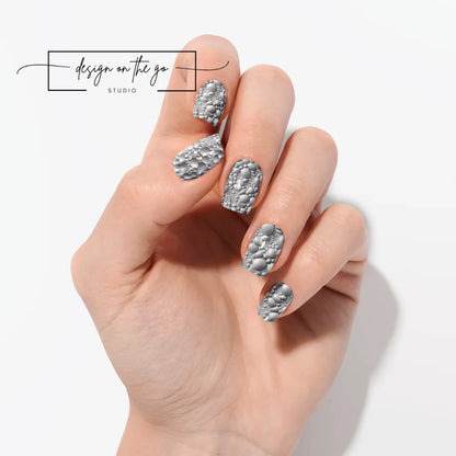#type_manicure one hand showing beautifully manicured nail with nail wraps applied on white background