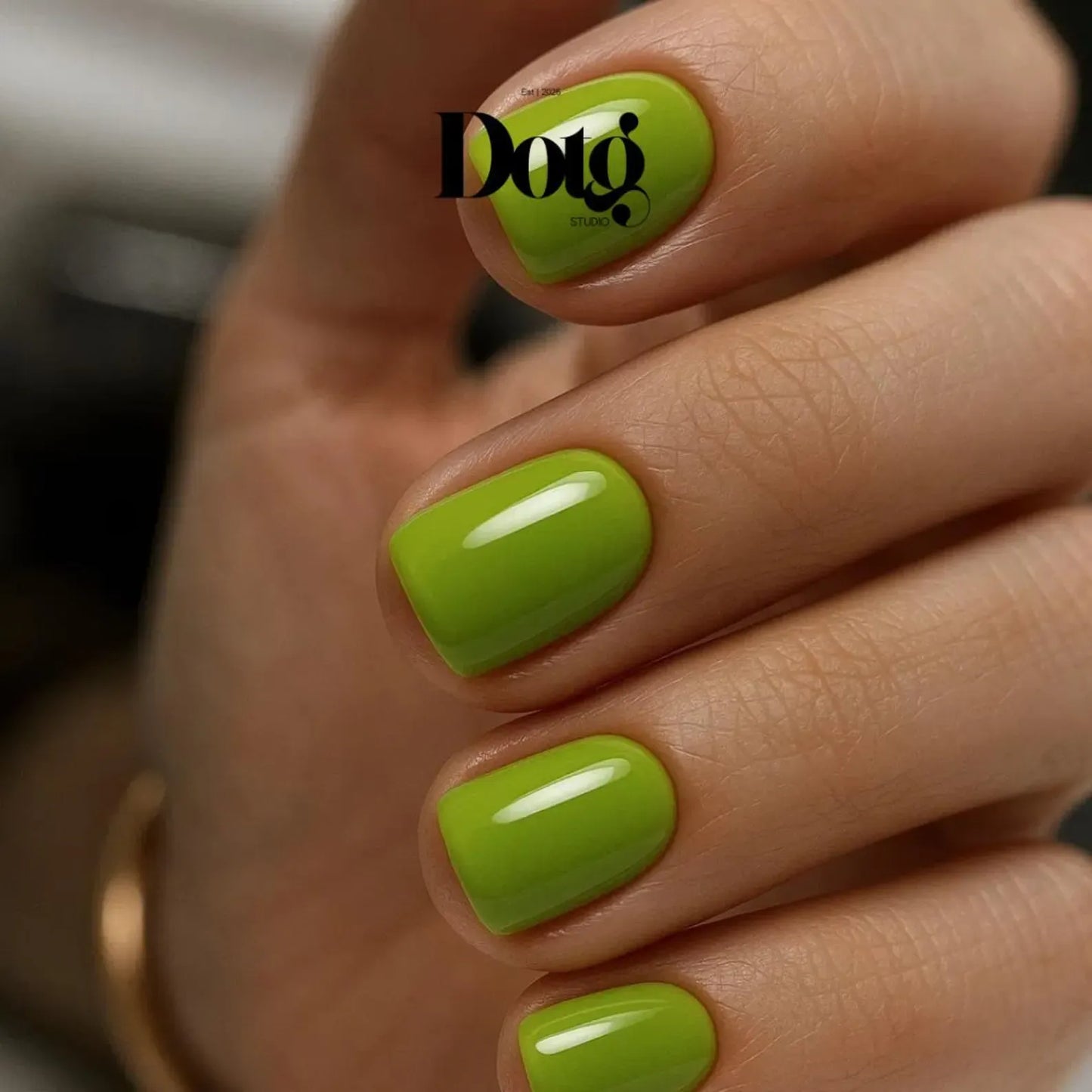 Hand with manicured fingernails with green nail wraps