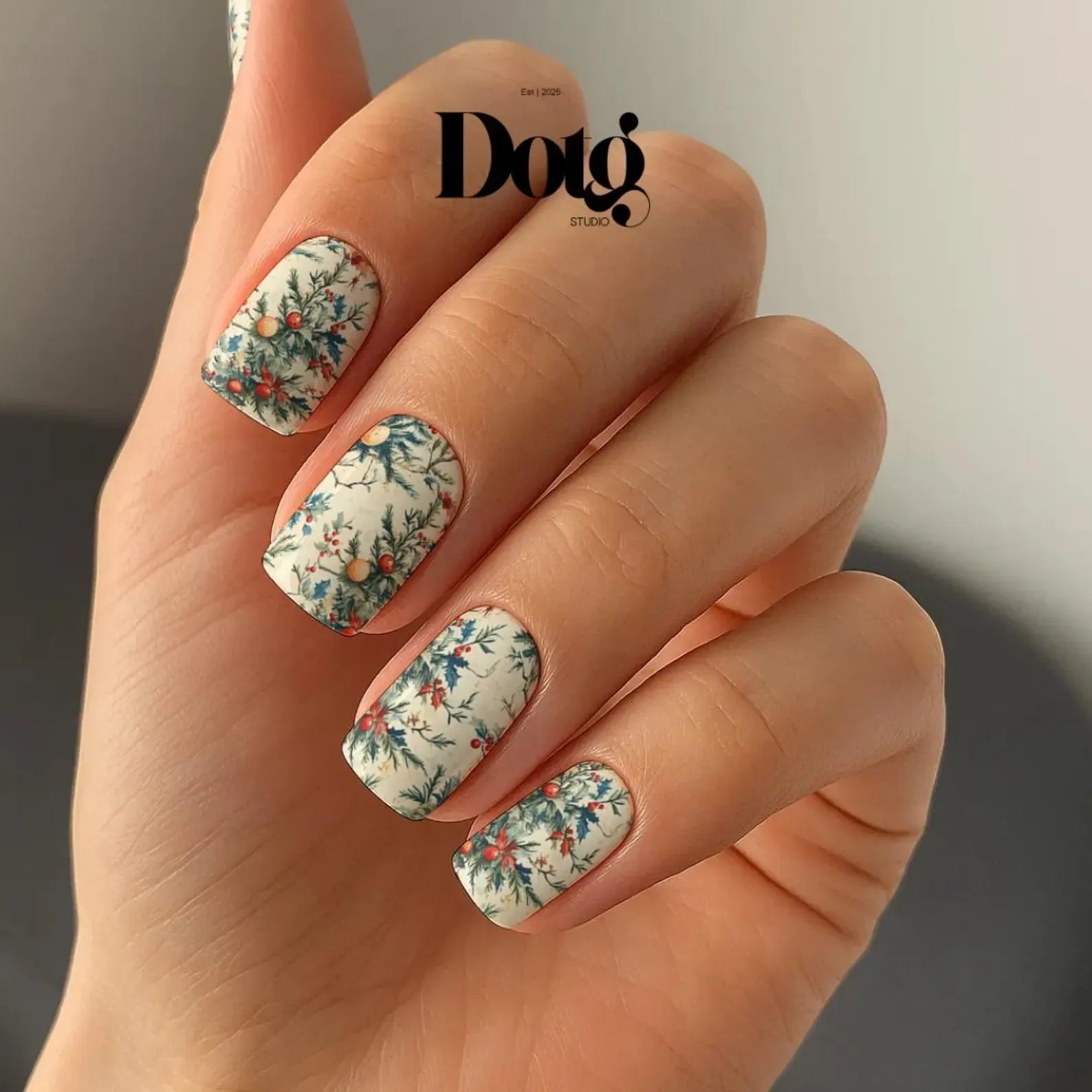 Manicured Hand with christmas floral nail wraps nail design.
