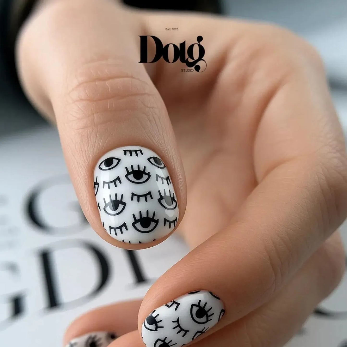 Nail art with black eye designs on white background