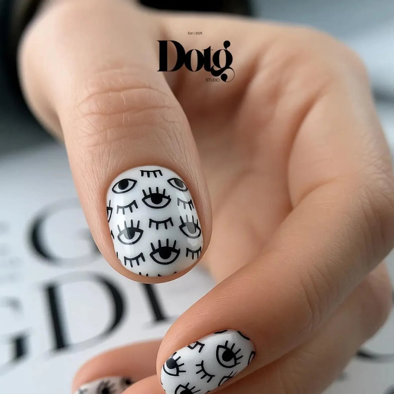Nail art with black eye designs on white background