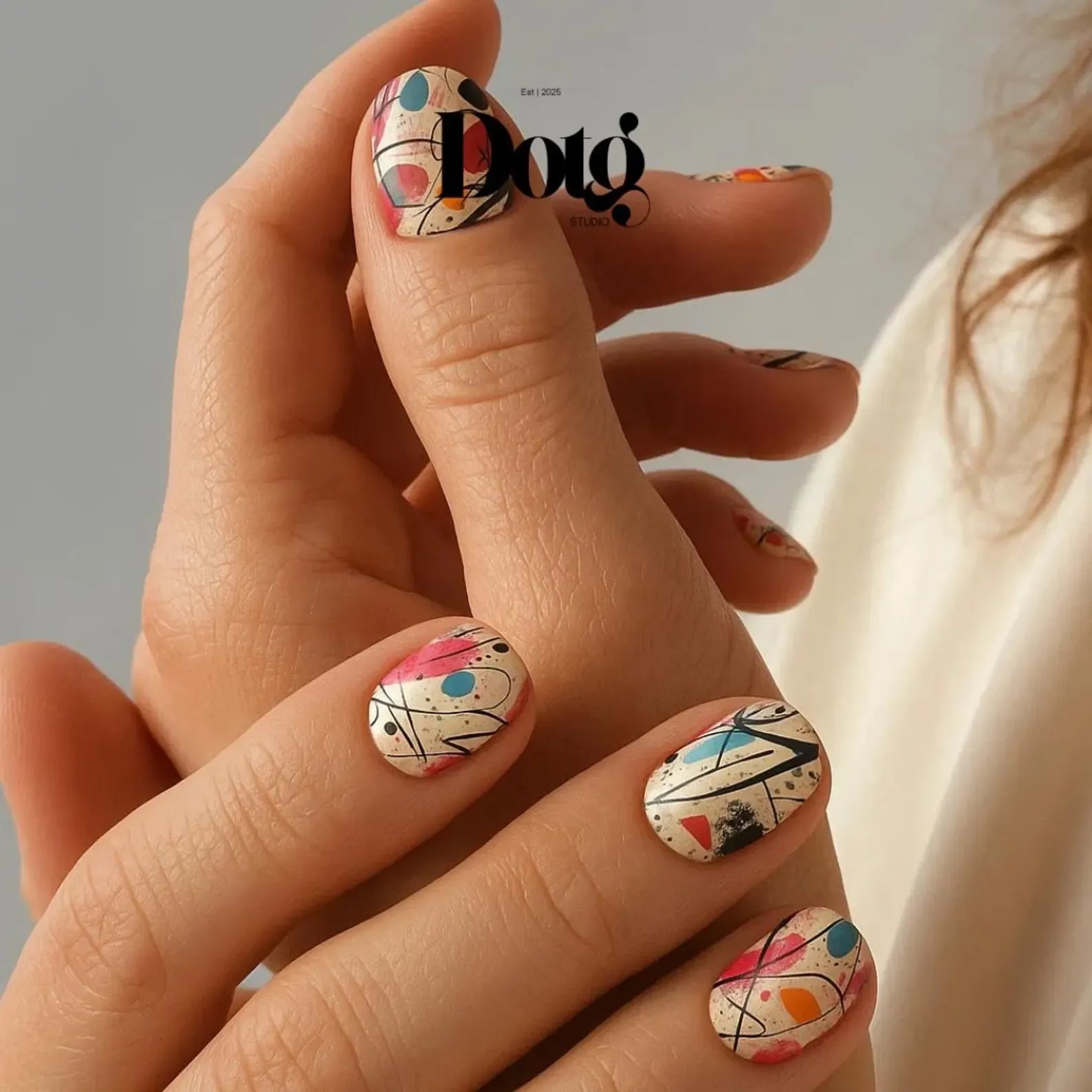 Close-up of a hand with colourful abstract nail art.