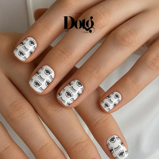 Nails with eye pattern design on a neutral background, featuring the Dotg brand.