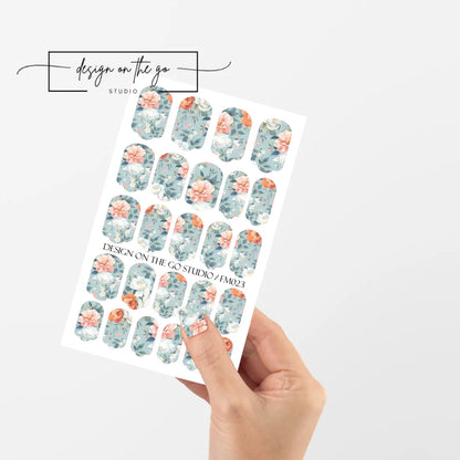 #type_manicure single hand with beautifully manicured nails with nail wraps holding full nail wraps sheet.