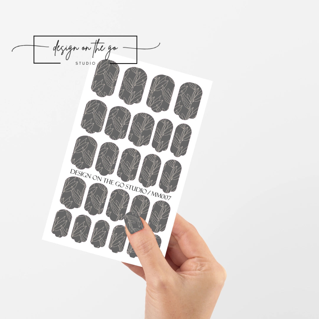 #type_manicure single hand with beautifully manicured nails with nail wraps holding full nail wraps sheet.