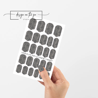 #type_manicure single hand with beautifully manicured nails with nail wraps holding full nail wraps sheet.