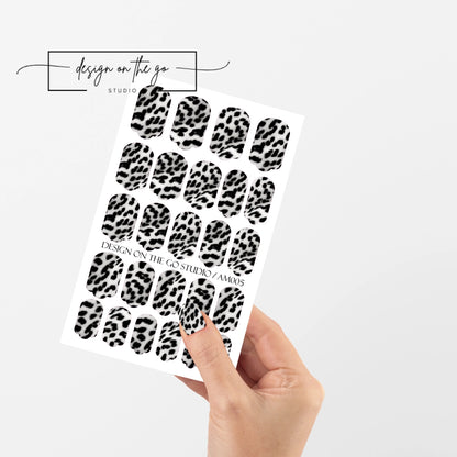 #type_manicure single hand with beautifully manicured nails with nail wraps holding full nail wraps sheet.